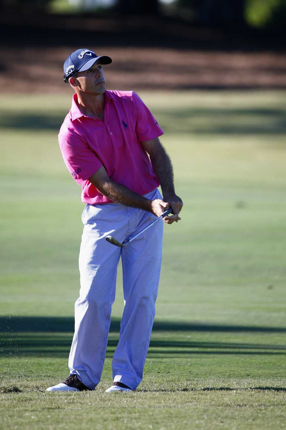 韩国球员准备击球，他目光如炬地望向远方的果岭，神情专注而冷静，仿佛周遭的一切都已静止。