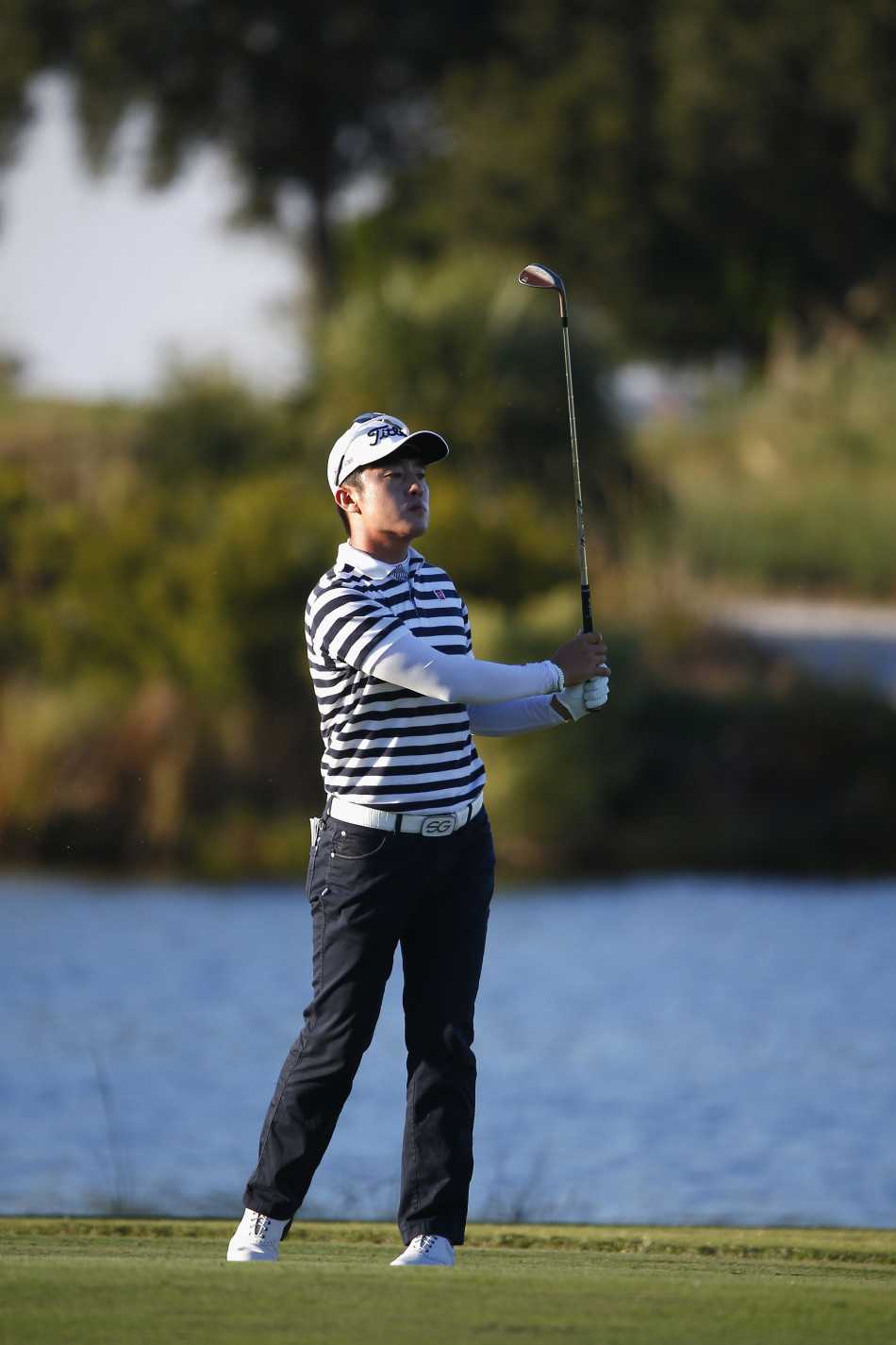 观众和球员一同伸长脖子，紧张地望向空中飞行的小球，脸上写满了“看看这个球如何”的期待与好奇。