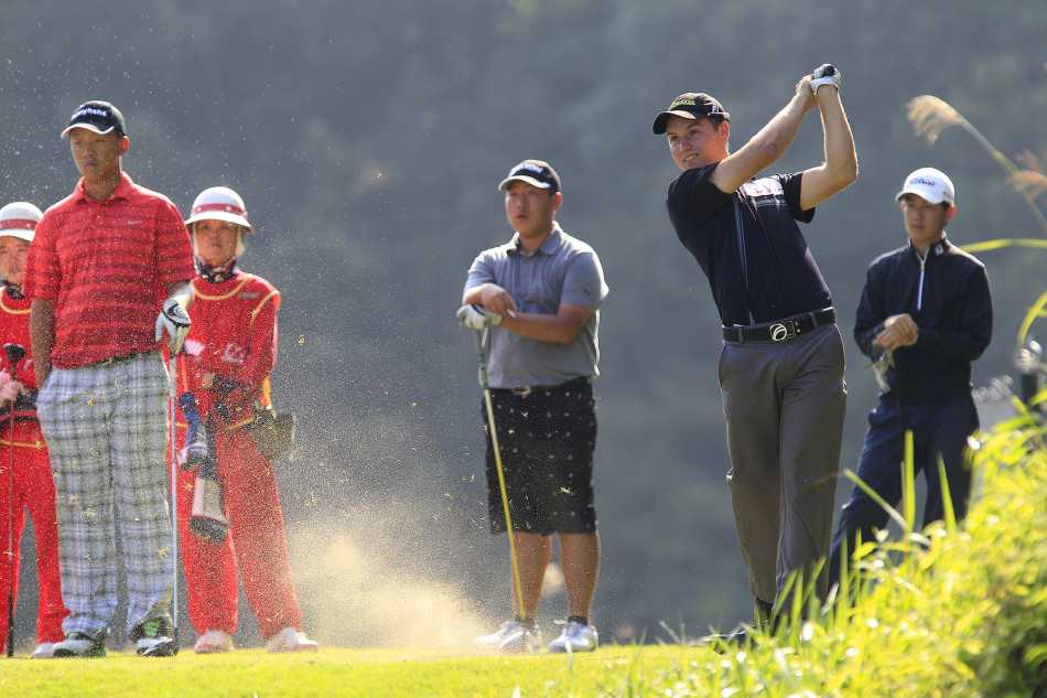 澳大利亚冠军球手贝雷克在果岭边专注地观察推杆线路，凝重的神情透露出比赛关键时刻的紧张气氛。