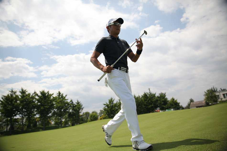 陈道明自信挥杆的瞬间，身体扭转形成完美的力量轴线，球杆划破空气，展现出经过千锤百炼的、举重若轻的掌控力