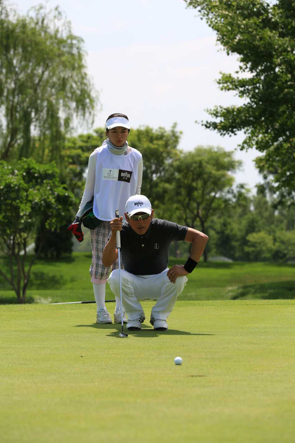 陈道明俯身进行关键推杆前的一刻，神情专注如磐石，世界仿佛静止，只剩他与球洞之间的无声对话