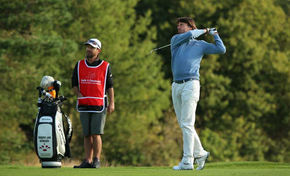 戴森在发球台凝神准备，身后是黑压压的寂静人群，大战一触即发。