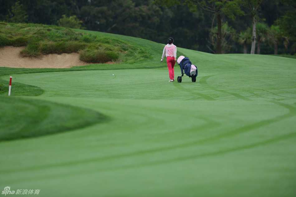 发球台上，小姑娘奋力挥杆的瞬间，身体扭转出充满力量的线条，她的父亲站在镜头远端，双手交握，神情紧张而专注，仿佛在默默传递力量。