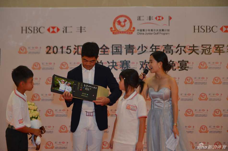 梁文冲作为前辈，正指着远方球场，向围在身边的小选手们生动讲解策略与技巧。