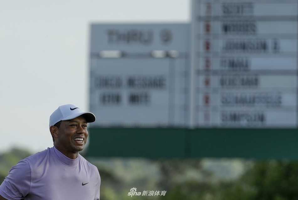 伍兹在果岭边凝神观察推杆线路，侧影专注，奥古斯塔的沙坑与绿草构成经典背景。