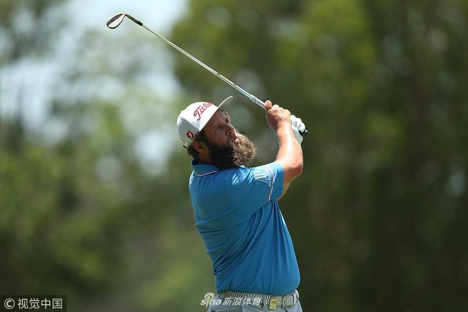 广阔的高尔夫球场全景，蓝天白云下，球道与湖泊构成一幅宁静而充满挑战的画卷