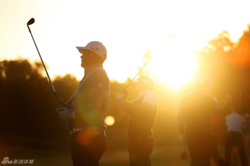 韩国选手李首民在长草区中审慎观察球位，准备进行一次困难的救球，表情认真专注。