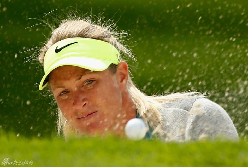 沙坑救球的艺术。球员挥杆瞬间，沙粒如金色瀑布般飞扬，展现出克服困境的爆发力与技巧之美。