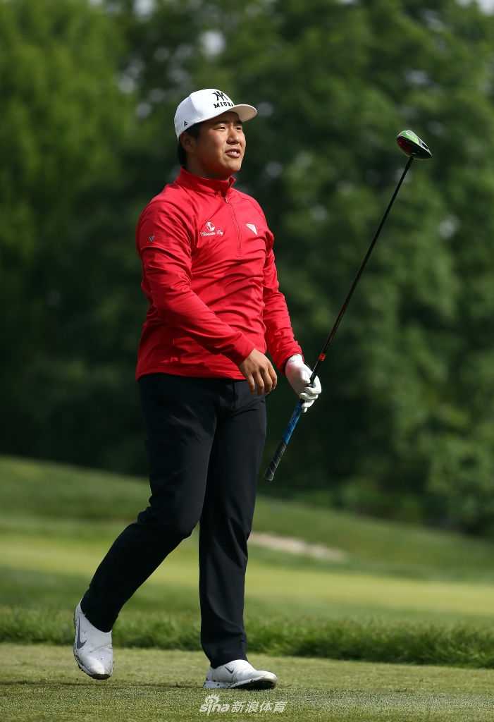 母子二人共同举起冠军奖杯，背景是广阔的绿茵场，画面充满胜利的喜悦与家庭的温馨。