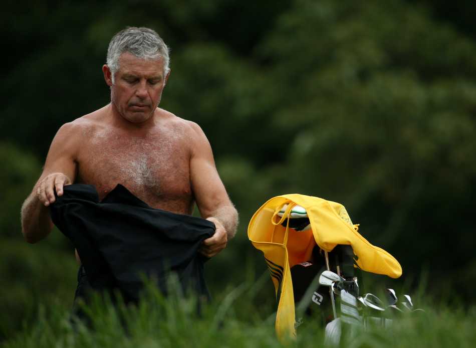 麦克罗伊在潮湿的球道上专注地观察线路，泥泞的赛场映衬着他坚毅的侧脸，冠军的气质在逆境中悄然凝聚。