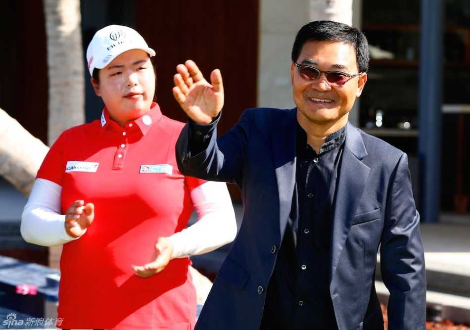 从高处俯瞰蓝湾大师赛开幕式现场，蓝天白云下，人群聚集，绿草如茵，一片盛大而欢庆的景象。