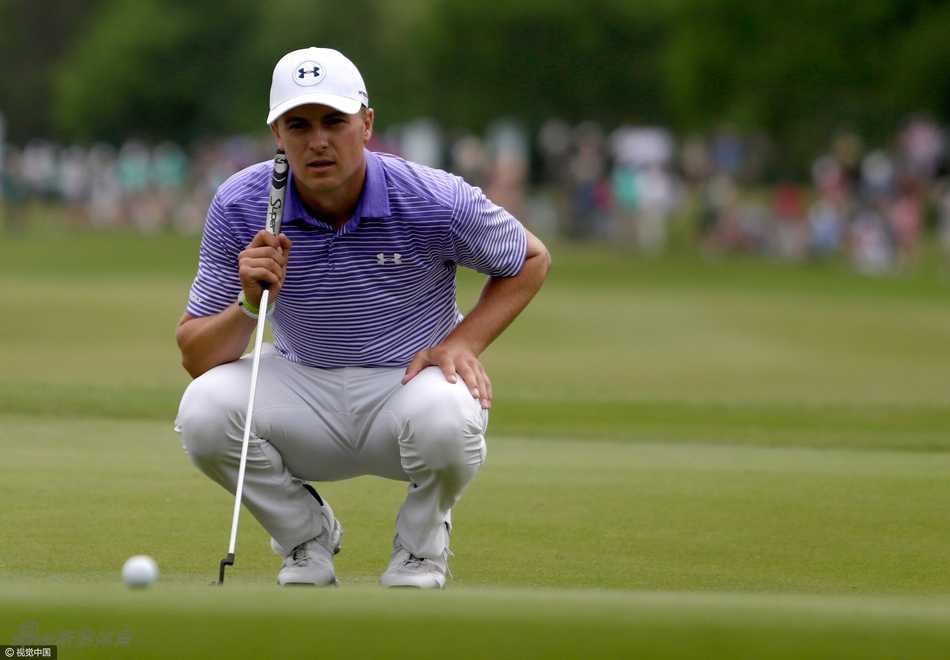 松山英树全神贯注地俯身观察果岭推杆线路，他的目光如鹰隼般锐利，计算着草纹与坡度对小白球行径的微妙影响。