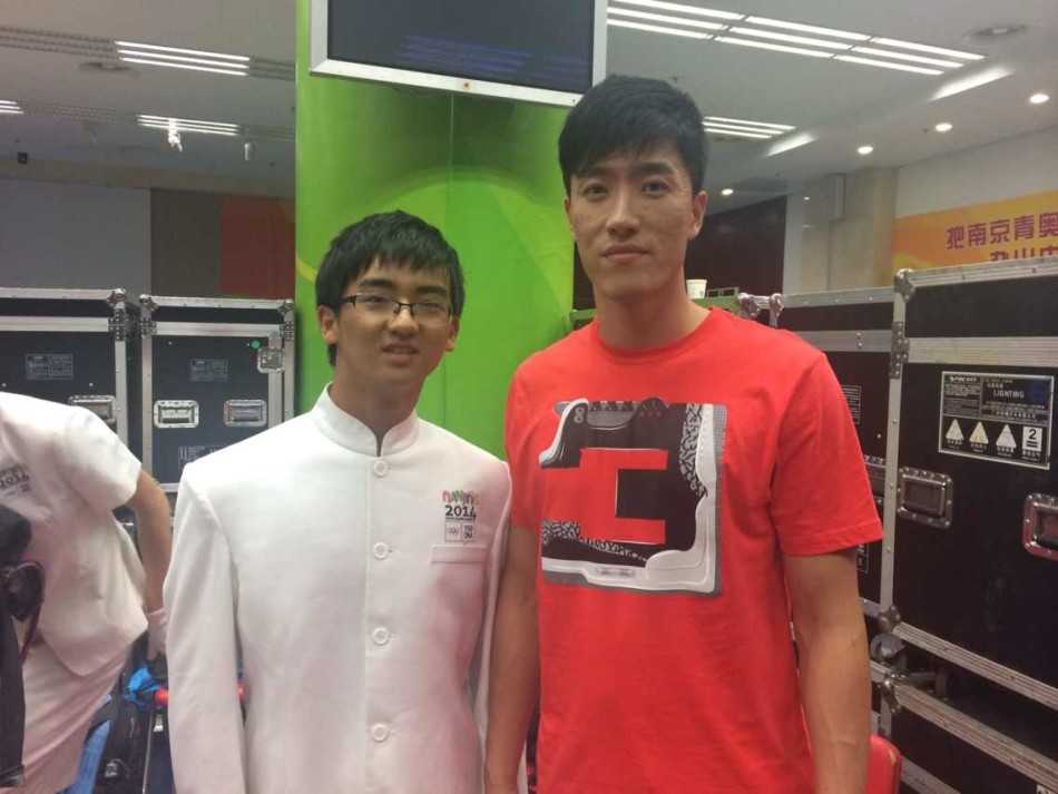 南京青奥会开幕式现场，璀璨的烟火在夜空中绽放，将奥体中心映照得如同白昼，象征着青春梦想被点亮