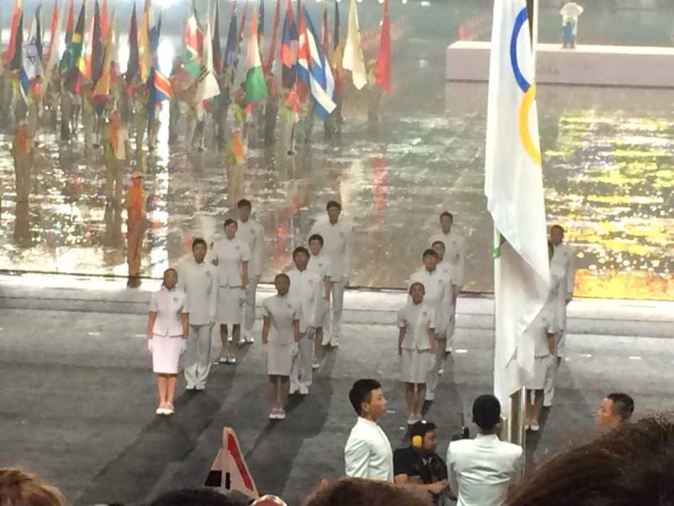 窦泽成与飞人刘翔在青奥会开幕式后台的合影，两人面带微笑，窦泽成手中拿着手机，记录下这难忘的时刻