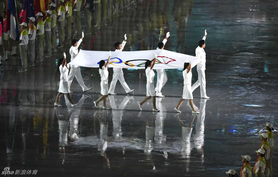 窦泽成（第二排左二）与其他七位青奥运动员执旗手并肩站立，他们手持奥林匹克会旗，神情庄重，准备完成历史性的交接