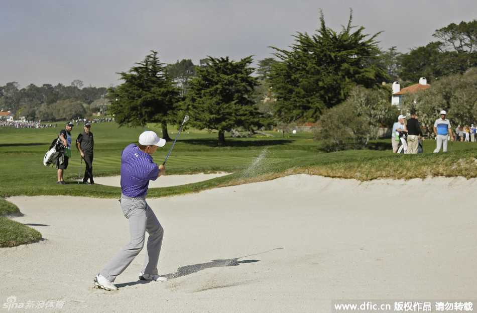 菲尔·米克尔森在比赛中轻松推击，小球应声入洞，背景是晴朗的天空和广阔的球场。